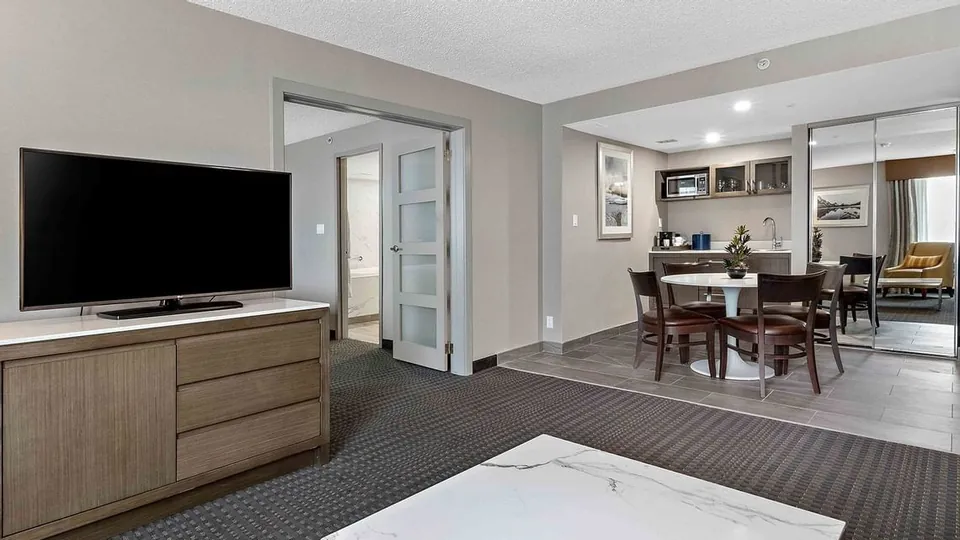 Living room and dining area in a Suite at Best Western Premier Calgary Plaza Hotel