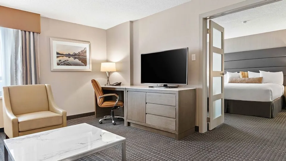 Living room and bedroom area in a Suite at Best Western Premier Calgary Plaza Hotel