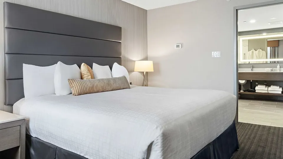 Bedroom and bathroom area in a Suite at Best Western Premier Calgary Plaza Hotel