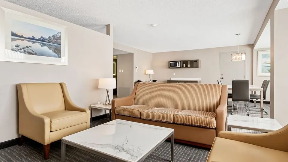 Living room and conference table in a Suite at Best Western Premier Calgary Plaza Hotel