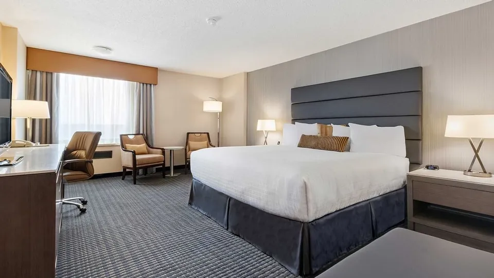 King bed and furniture in the Premier Room at Best Western Premier Calgary Plaza Hotel