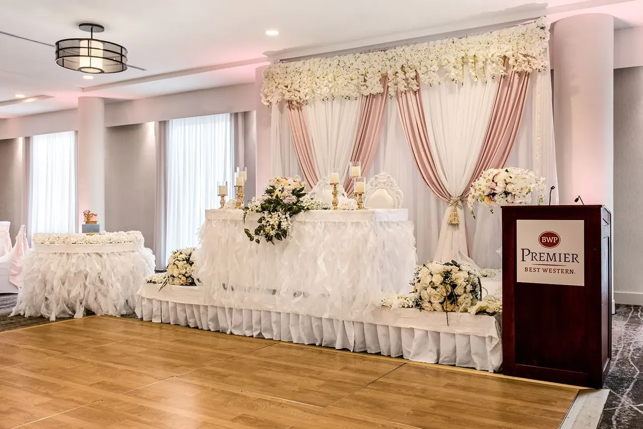 Floral head table décor and dance floor at the Best Western Premier Calgary Plaza Hotel